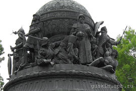 A monument to thousandth anniversary of Russia (1862). «Foundation of an independent Russian Tsardom»:   Ivan the Great in a dress of Byzantine emperors with Monomach's Cap. In his hands he holds a scepter and a globus cruciger. In front of him, a Tatar is kneeling, beside him, a Lithuanian is lying, representing Grand Duchy of Lithuania, as well as a Teutonic knight with a broken sword, representing the Order of Teutonic Knights.